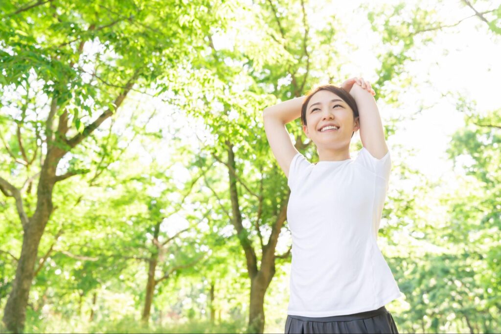 森の中でストレッチする女性の画像